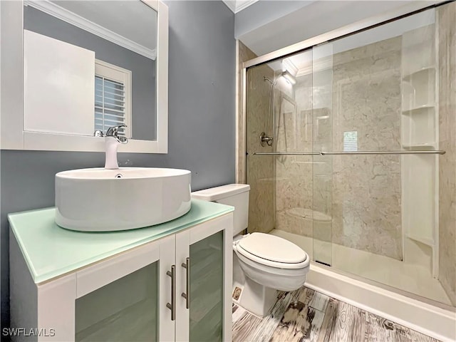 bathroom featuring an enclosed shower, vanity, crown molding, hardwood / wood-style floors, and toilet