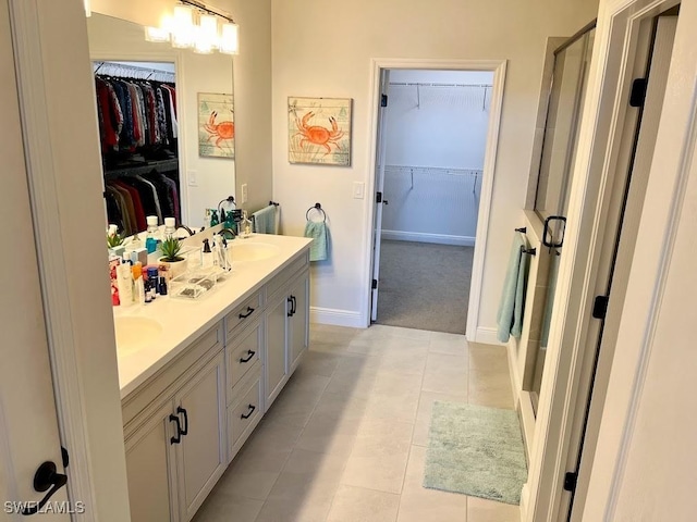 bathroom featuring a shower with shower door, vanity, and tile patterned floors