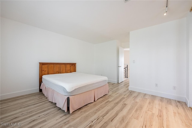 bedroom featuring light wood-type flooring and rail lighting