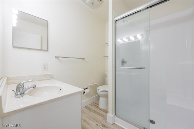 bathroom with vanity, toilet, a shower with door, and hardwood / wood-style flooring