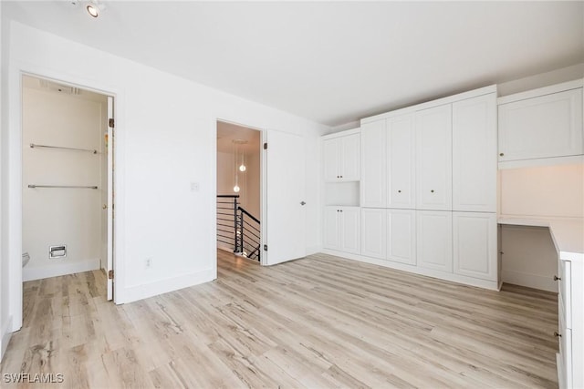 18038 San Carlos Blvd Unit 113, Fort Myers Beach, FL 33931 - unfurnished bedroom featuring light wood finished floors, a closet, and baseboards