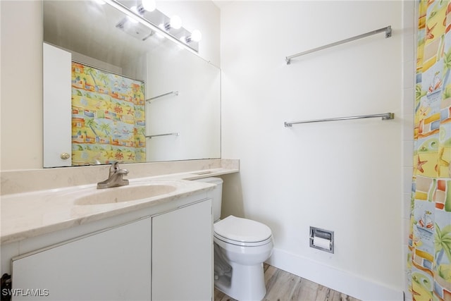 bathroom featuring wood-type flooring, vanity, toilet, and curtained shower