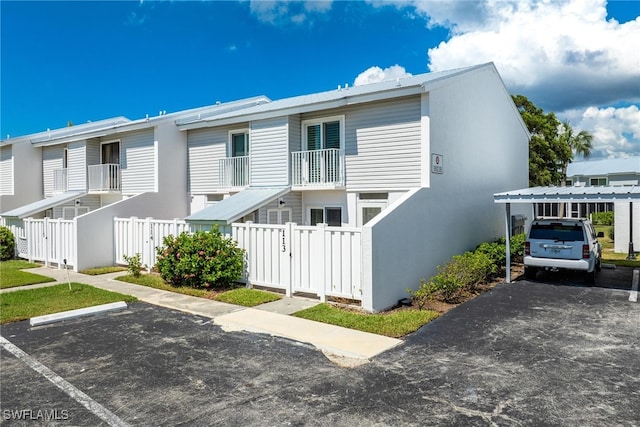 view of front of property featuring a balcony and central AC unit