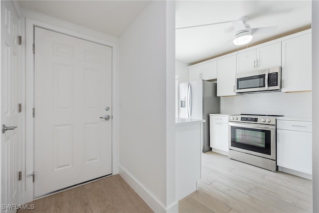 kitchen with ceiling fan, white cabinets, light hardwood / wood-style flooring, backsplash, and stainless steel appliances