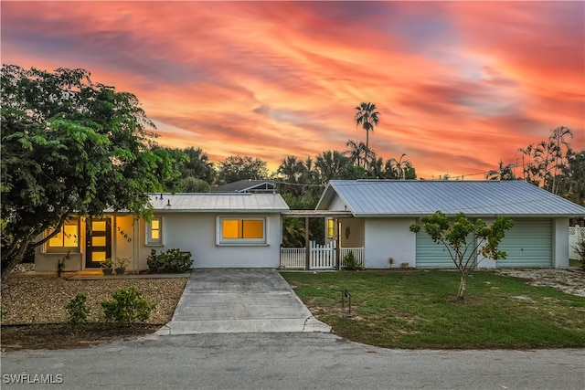 single story home featuring a garage and a yard