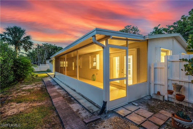 property exterior at dusk with a sunroom