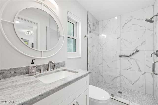 bathroom with walk in shower, vanity, and toilet