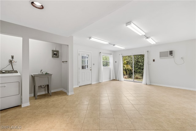 tiled empty room featuring an AC wall unit and washer / clothes dryer