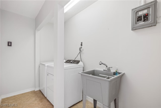 washroom with independent washer and dryer, light tile patterned floors, and sink