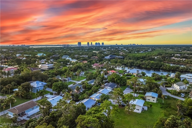 aerial view at dusk featuring a water view