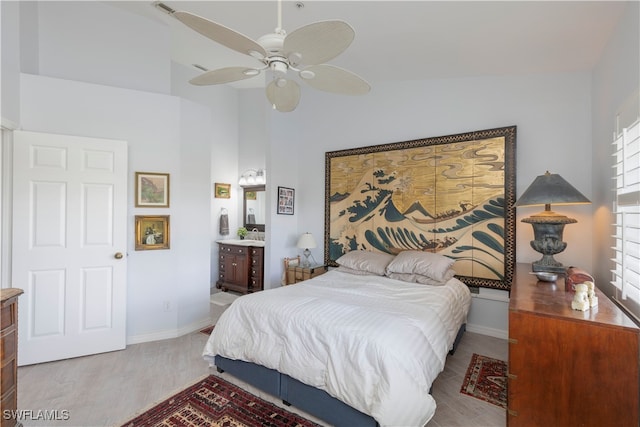 bedroom with connected bathroom, vaulted ceiling, light hardwood / wood-style floors, and ceiling fan