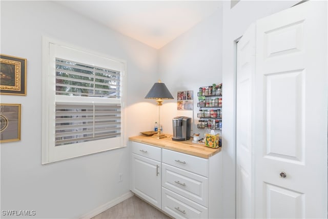 interior space featuring butcher block countertops and white cabinetry