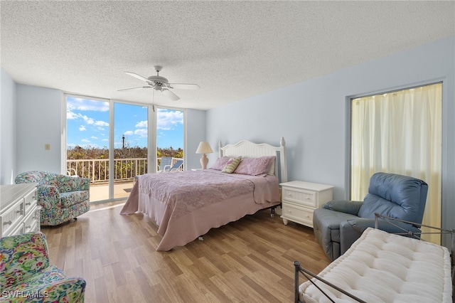 bedroom with access to outside, floor to ceiling windows, ceiling fan, and light hardwood / wood-style flooring