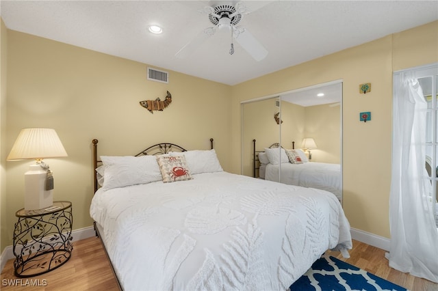 bedroom featuring wood-type flooring, ceiling fan, and a closet