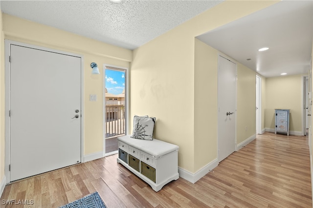 entryway featuring light wood-type flooring and a textured ceiling