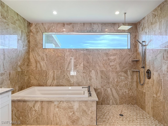 bathroom featuring independent shower and bath, vanity, and tile walls