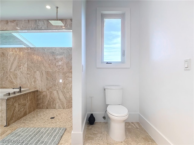 bathroom with a tile shower and toilet