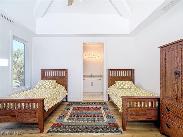 9345 Dimmick Dr, Sanibel, FL 33957 - bedroom featuring light wood-style floors, ensuite bathroom, beam ceiling, and visible vents