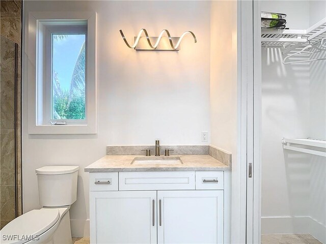 9345 Dimmick Dr, Sanibel, FL 33957 - full bathroom with vanity, a walk in closet, a tile shower, and toilet