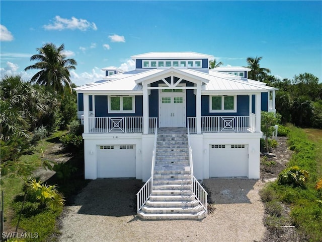 9345 Dimmick Dr, Sanibel, FL 33957 - raised beach house with stairs, a garage, driveway, and a porch