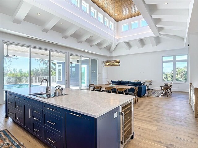 9345 Dimmick Dr, Sanibel, FL 33957 - kitchen featuring beamed ceiling, beverage cooler, open floor plan, light wood finished floors, and blue cabinetry