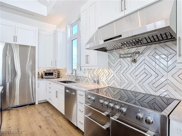 9345 Dimmick Dr, Sanibel, FL 33957 - kitchen with under cabinet range hood, stainless steel appliances, white cabinetry, and a sink