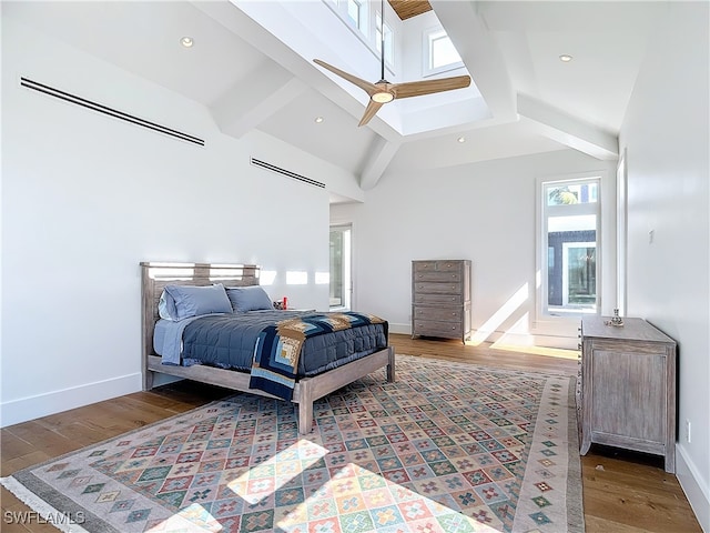 bedroom featuring beam ceiling, dark hardwood / wood-style flooring, ceiling fan, and high vaulted ceiling