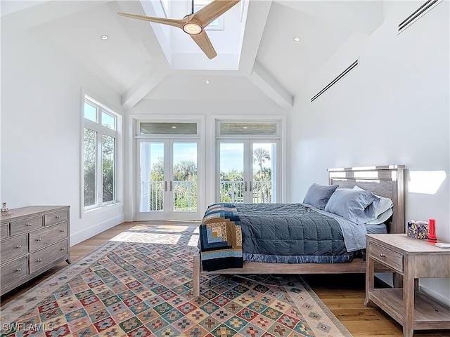 bedroom featuring lofted ceiling with beams, ceiling fan, french doors, and hardwood / wood-style flooring