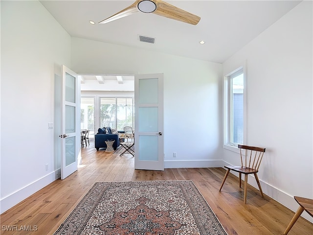 living area with french doors, lofted ceiling, and light hardwood / wood-style floors