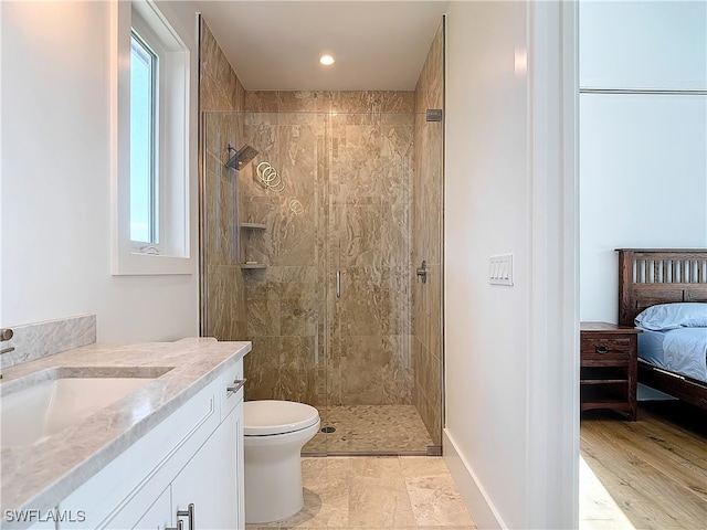 bathroom featuring a tile shower, vanity, toilet, and hardwood / wood-style flooring