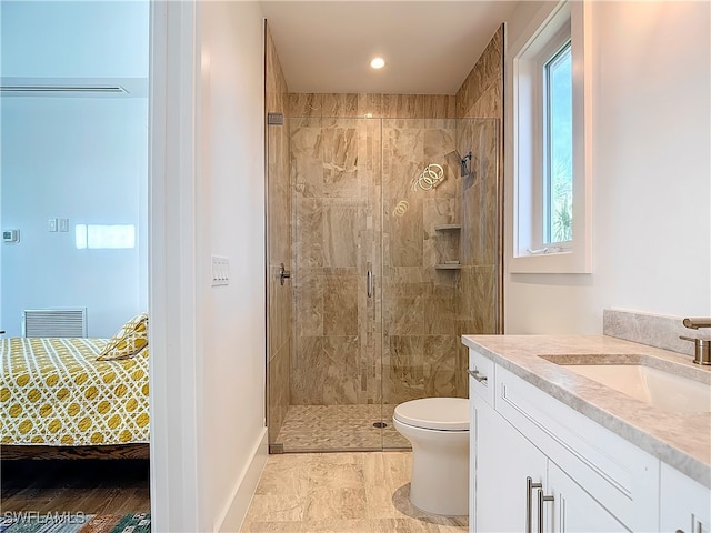 bathroom with a shower with shower door, vanity, and toilet