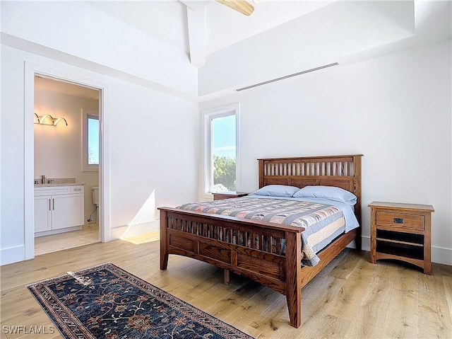 bedroom with connected bathroom, light hardwood / wood-style floors, and ceiling fan