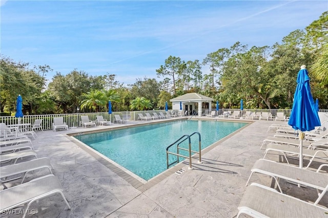 community pool with fence and a patio area