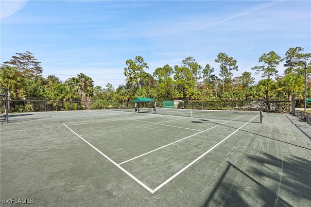 view of tennis court featuring fence and community basketball court