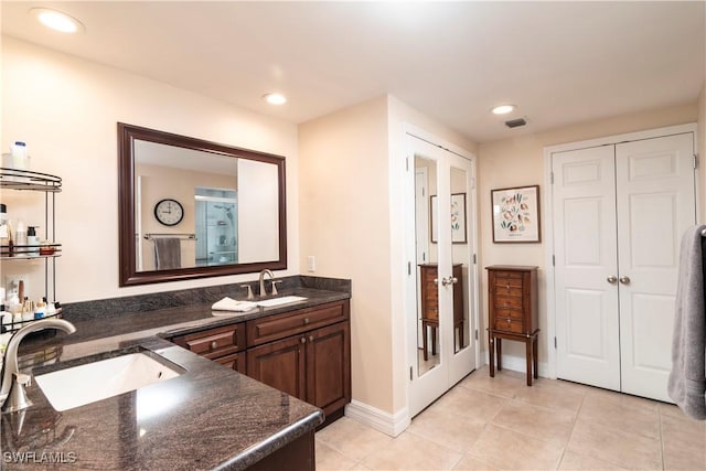 bathroom featuring tile patterned floors, french doors, and vanity