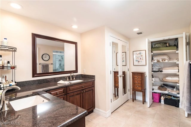 bathroom featuring tile patterned flooring, vanity, and french doors