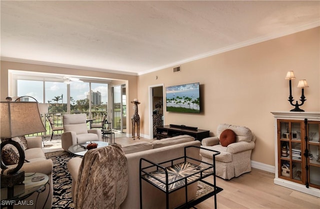 living room featuring light wood-type flooring, ceiling fan, and ornamental molding