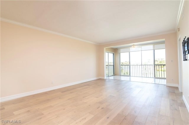 empty room with crown molding, baseboards, and light wood-type flooring