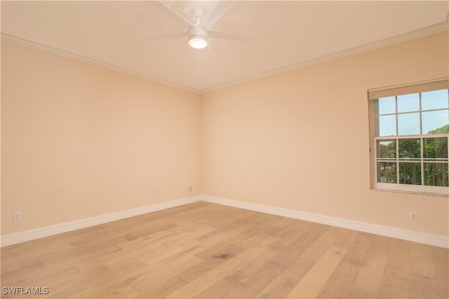 spare room with baseboards, light wood-style floors, ornamental molding, and ceiling fan