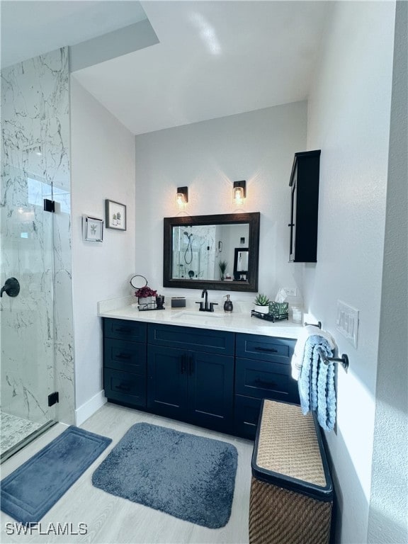 bathroom with vanity, a shower with shower door, and hardwood / wood-style floors