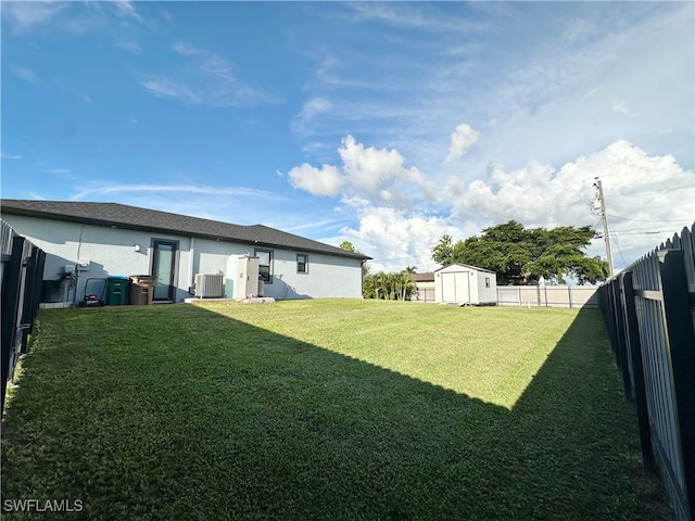 view of yard featuring a shed and central AC