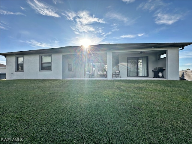 rear view of property featuring a patio, a yard, and ceiling fan