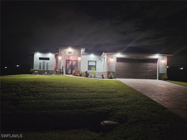 view of front of home with a yard and a garage