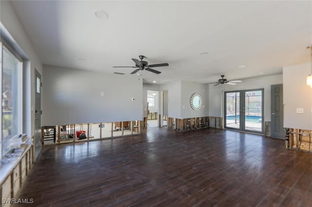 unfurnished living room with dark wood-type flooring, french doors, and ceiling fan