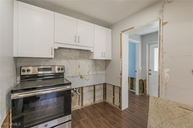 kitchen featuring decorative backsplash, stainless steel electric stove, and white cabinets