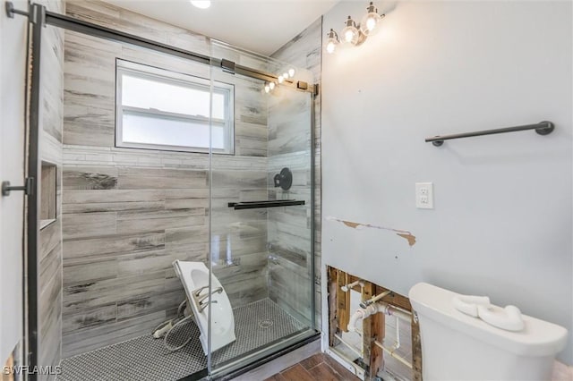 bathroom with hardwood / wood-style floors, toilet, and walk in shower