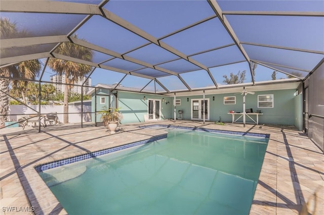 view of pool featuring french doors, ceiling fan, glass enclosure, and a patio