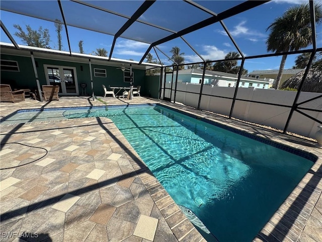 view of swimming pool with french doors, a patio area, and glass enclosure