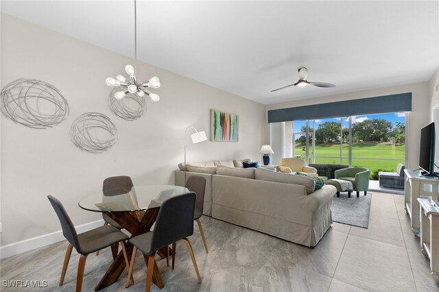 living room featuring ceiling fan with notable chandelier