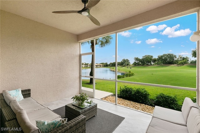 sunroom featuring a water view and ceiling fan